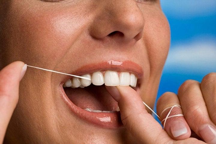 Sử dụng chỉ nha khoa để loại bỏ thức ăn bám trong kẽ răng.